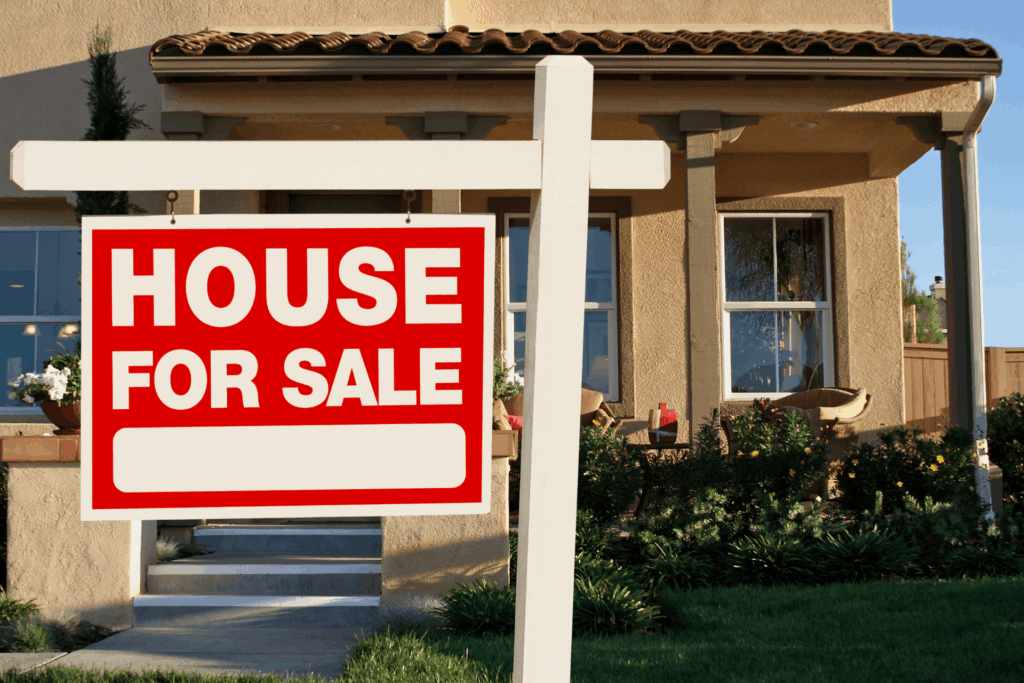  House with a ‘House for Sale’ sign displayed in the front yard.